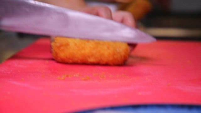 Plating the cheese pork cutlet cut from the cutting board onto a plate