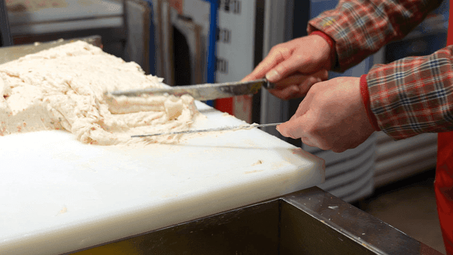 Fish cake mixture being shaped with a knife