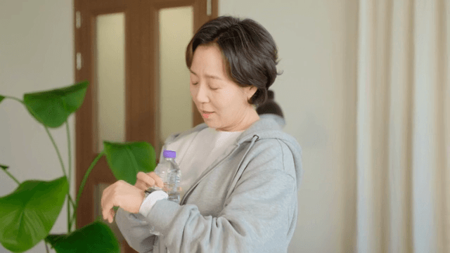 실내에서 스마트워치를 확인하는 여성