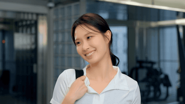 헬스장에서 가방을 매고 미소 짓는 여성의 옆모습