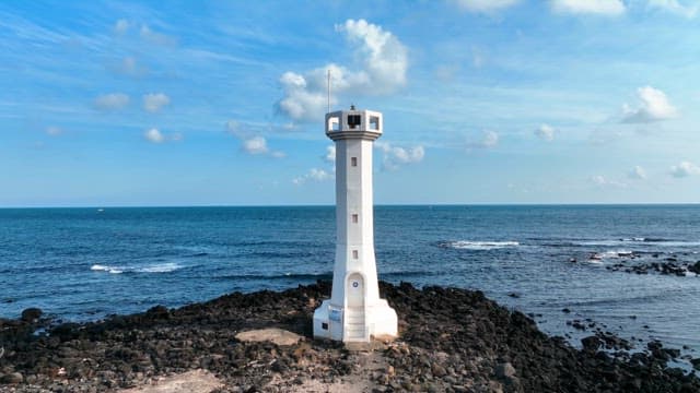 Lighthouse by the rocky seashore