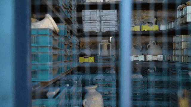Storage room with stacked crates and pottery