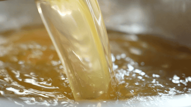 Golden broth being poured into pot