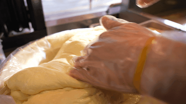 Hands kneading dough in a kitchen