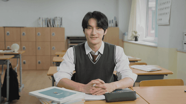 Male student smiling while sitting in the classroom