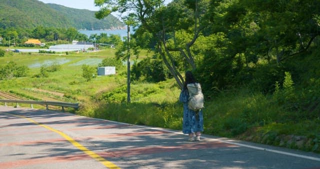 Woman Leisurely Walking on Street Enjoying the Weather