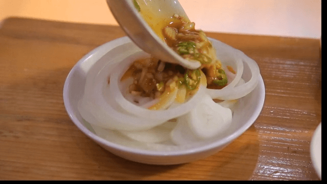 Sliced onions with sauce being prepared