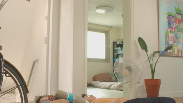 팔 깁스를 하고 거실에 누워 있는 남자와 여자