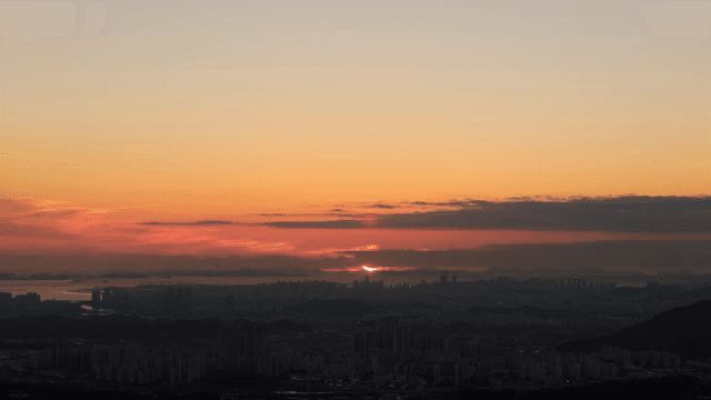 산과 도시 스카이라인 위의 일몰