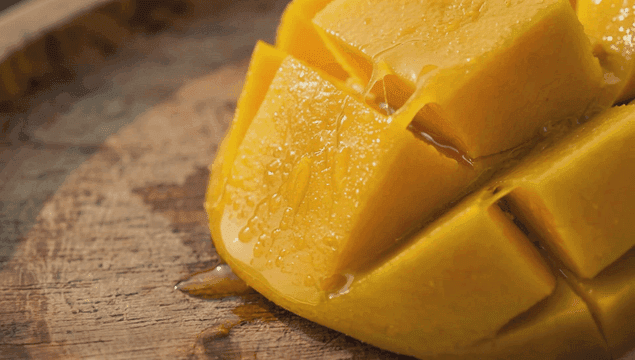 나무 도마 위의 망고 조각