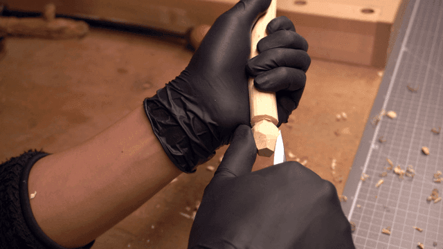 Person carving wood with precision
