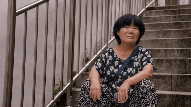 계단에 앉아 하늘을 바라보는 노인 여성