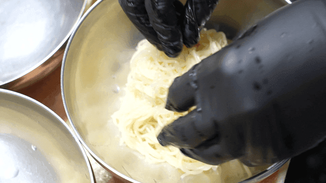 Noodles being prepared in a kitchen