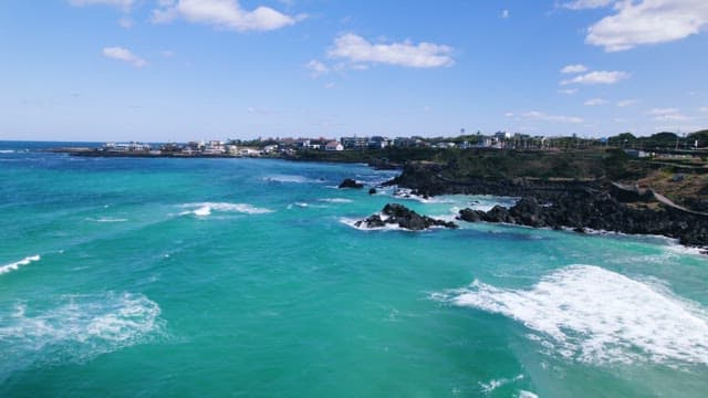 Coastal Town with Turquoise Waters and Black Rocks