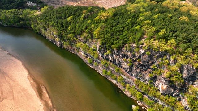 Serene river flowing beside rocky cliffs