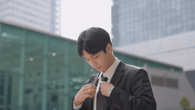 Office worker fixing his tie in front of a building