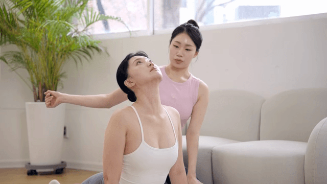 Pilates instructor guiding a student indoors