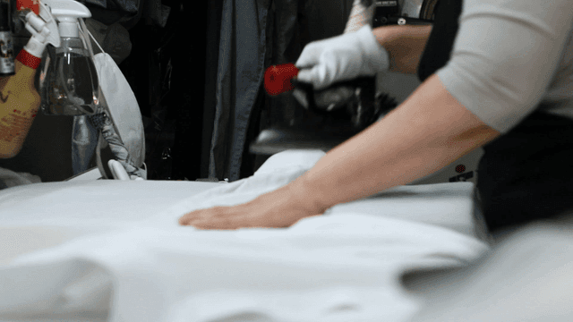 Person ironing clothes in a laundry shop