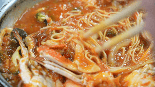 Seafood pasta boiling in pan
