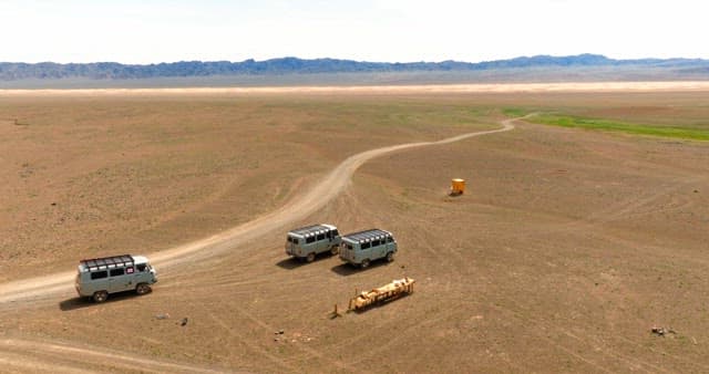 Vans traveling through a vast desert landscape