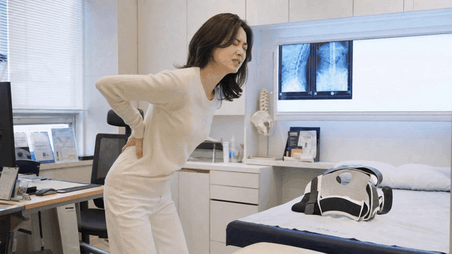 Woman experiencing back pain in a clinic