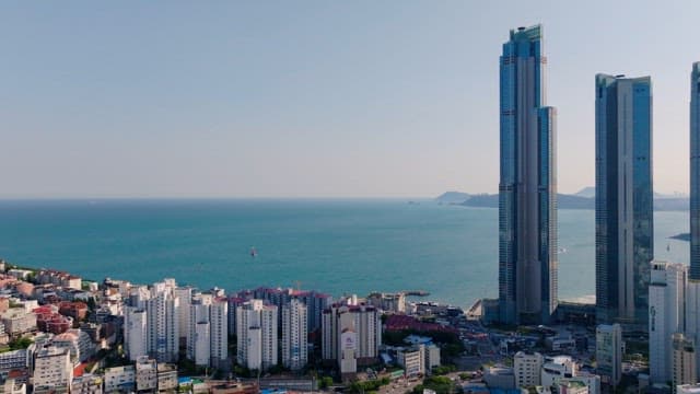 Coastal city with tall skyscrapers and dense residential complex by the sea