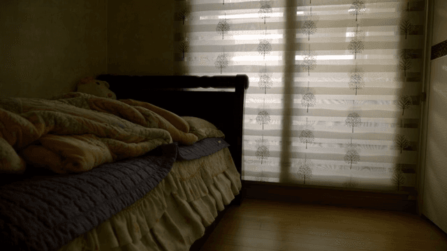 침대에 누워서 핸드폰을 하는 사람