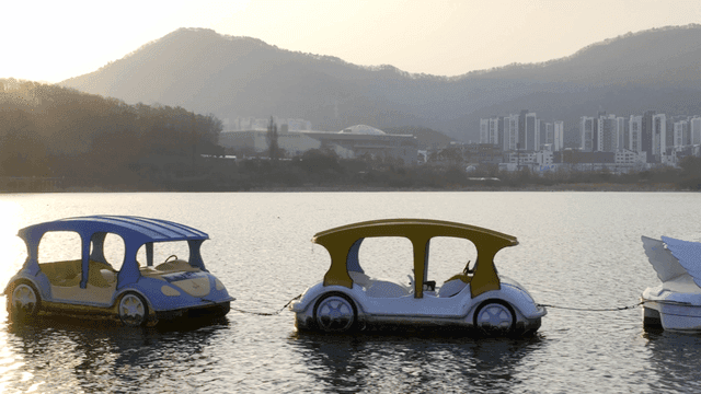 Paddle boats on a serene lake at sunset