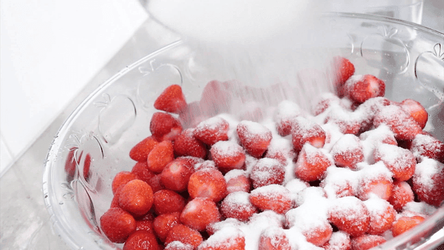 딸기 위에 설탕을 붓는 장면