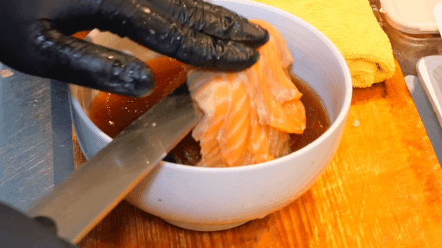 연어 슬라이스를 소바 위에 올리는 장면