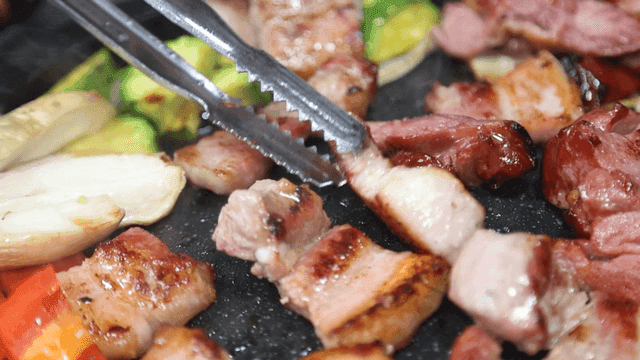 Grilling pork belly with vegetables on grill