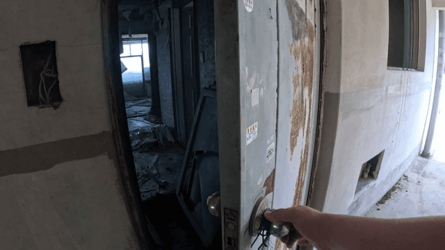 Opening a rusty door in an old building