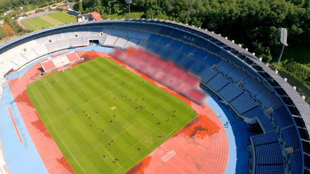 Soccer players practicing in a large football stadium