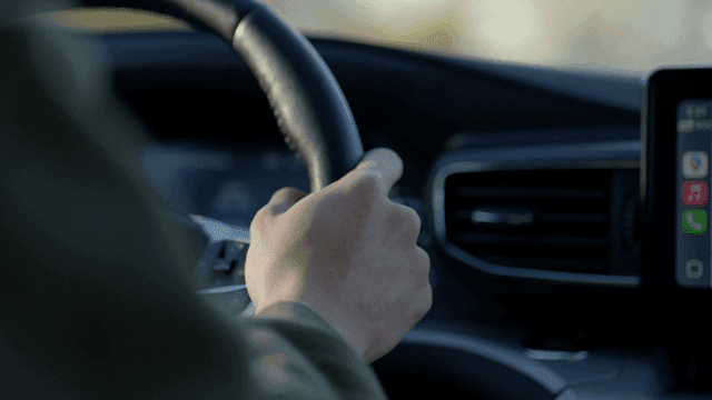 Person driving a car with focus on hands