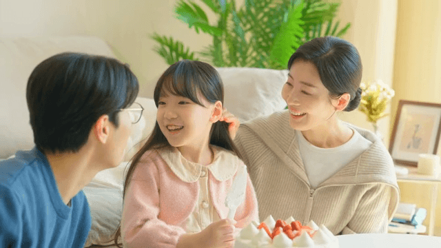 실내에서 케이크로 축하하는 가족