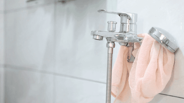 Bathroom faucet with pink shower towel hanging