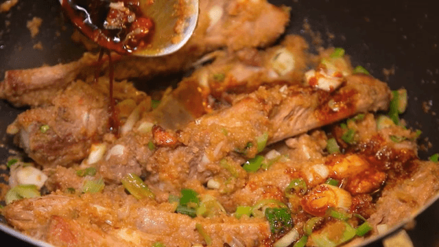 Soy sauce being poured over seasoned ribs