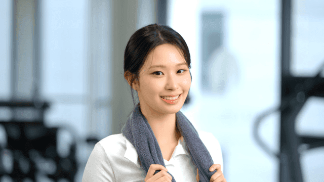 운동 후 정면을 보고 미소 짓는 젊은 여성