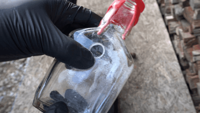 유리병을 들고 있는 장갑 낀 손