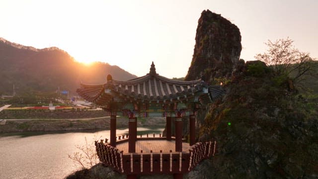 Traditional pavilion by the river at sunset