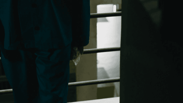 Prisoner entering his cell holding bread