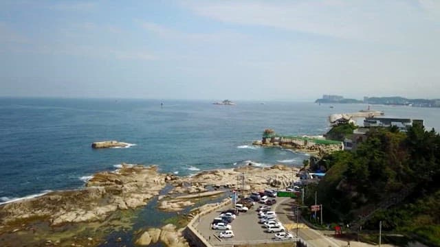 Rocky beach and sea close to the road with cars