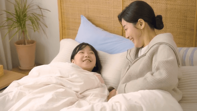침대에서 미소 짓는 엄마와 아이