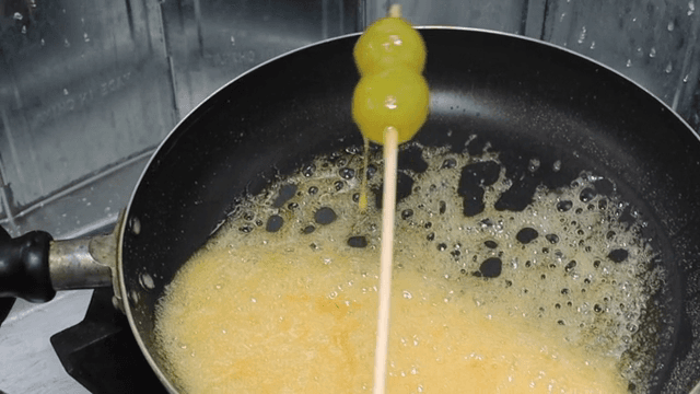 Making Tanghulu by applying syrup boiled in a pan