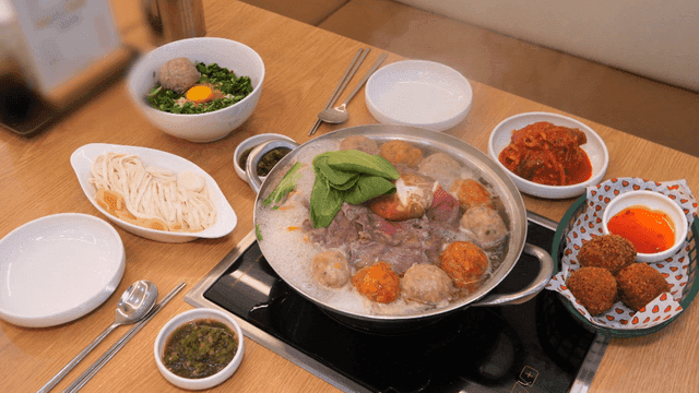 Table set with rolled dumpling hot pot and side dishes