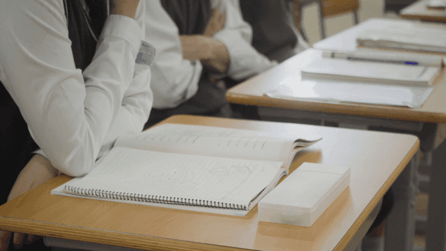 Students taking notes in the classroom with doodles in their notebooks