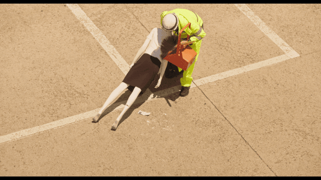 주차장에 놓인 여성 마네킹을 치우는 청소부