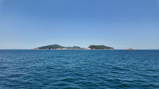 View of distant islands from the sea under a clear blue sky