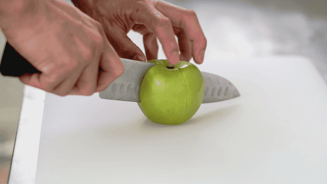 도마 위에서 녹색 사과 자르기