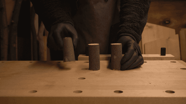 작업대 위에 나무 조각를 정리하는 사람